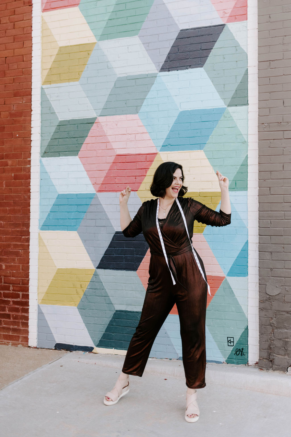 Kimmay in front of cube-painted brick wall